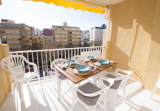 Terraza con mesa y sillas frente a la piscina