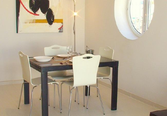 El salón-comedor cuenta con un sofá, una televisión y una mesa de comedor con sillas.