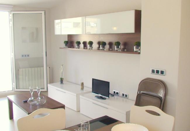 El salón-comedor cuenta con un sofá, una televisión y una mesa de comedor con sillas.