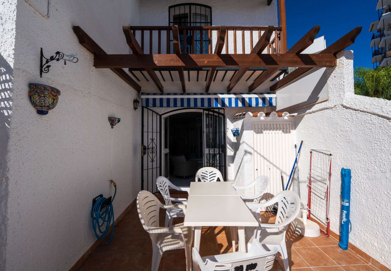 Terraza privada con tumbonas y zona de comedor exterior en Nerja.
