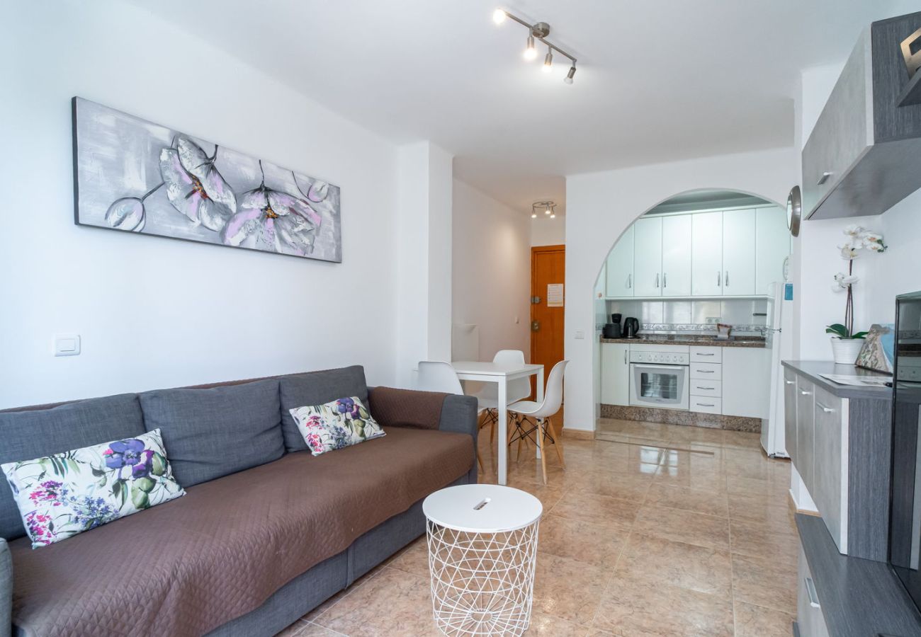 Salón-comedor con cocina integrada en apartamento vacacional en Nerja.