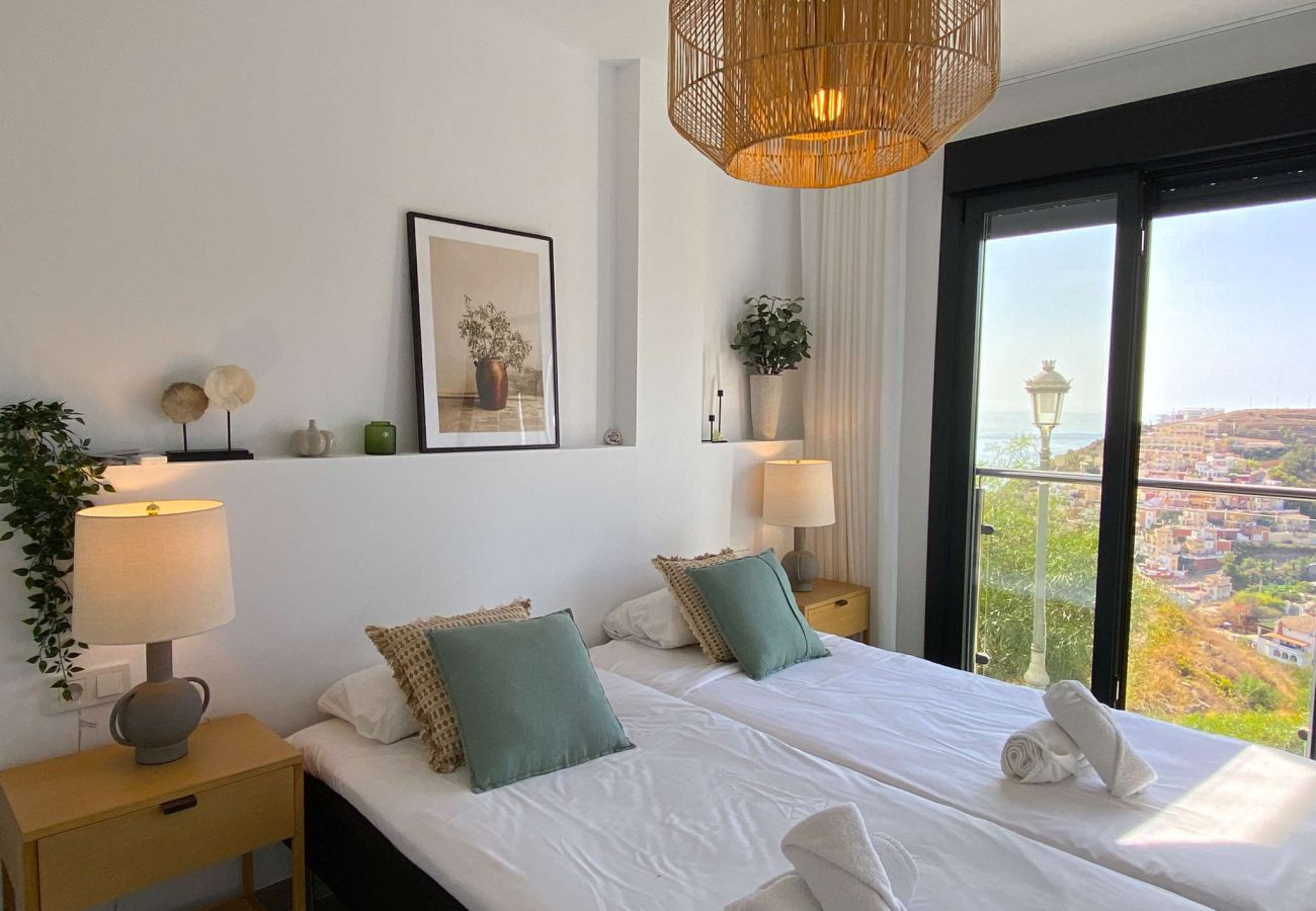 Dormitorio con cama doble decorado con vistas a la montaña en Nerja.