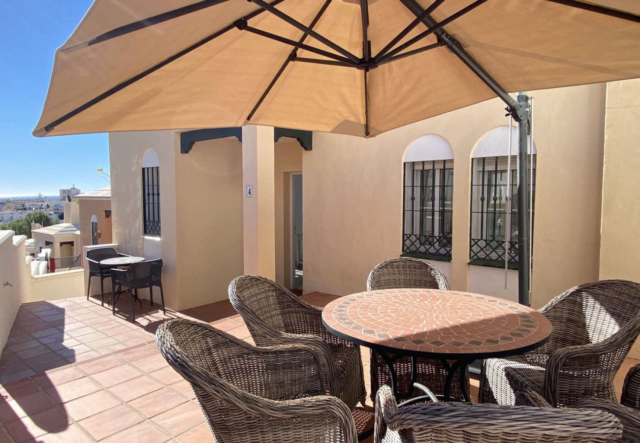 Terraza privada con zona de barbacoa y comedor exterior en Villa Lucena.