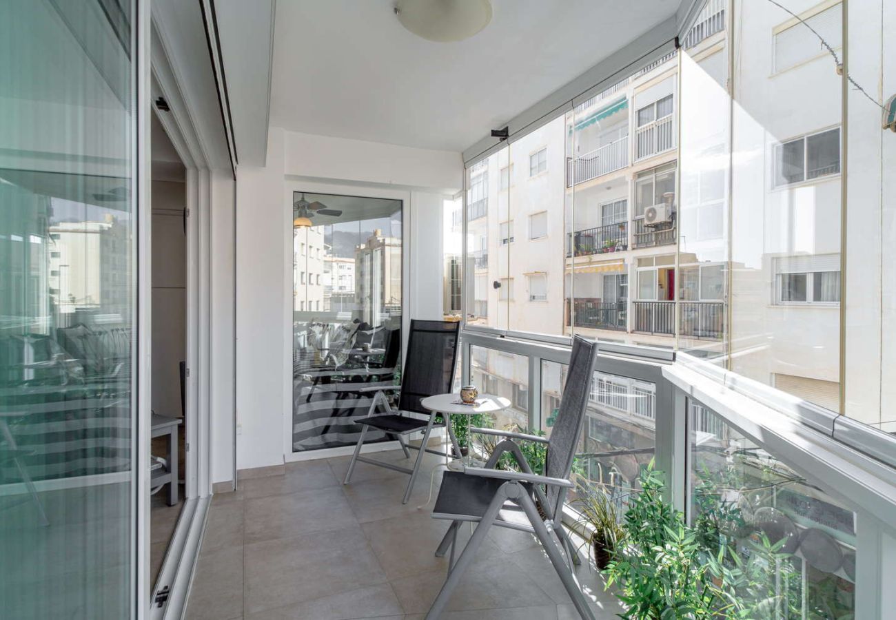 Balcón cerrado con cristalera y zona de estar para desayunos en Nerja Centro.