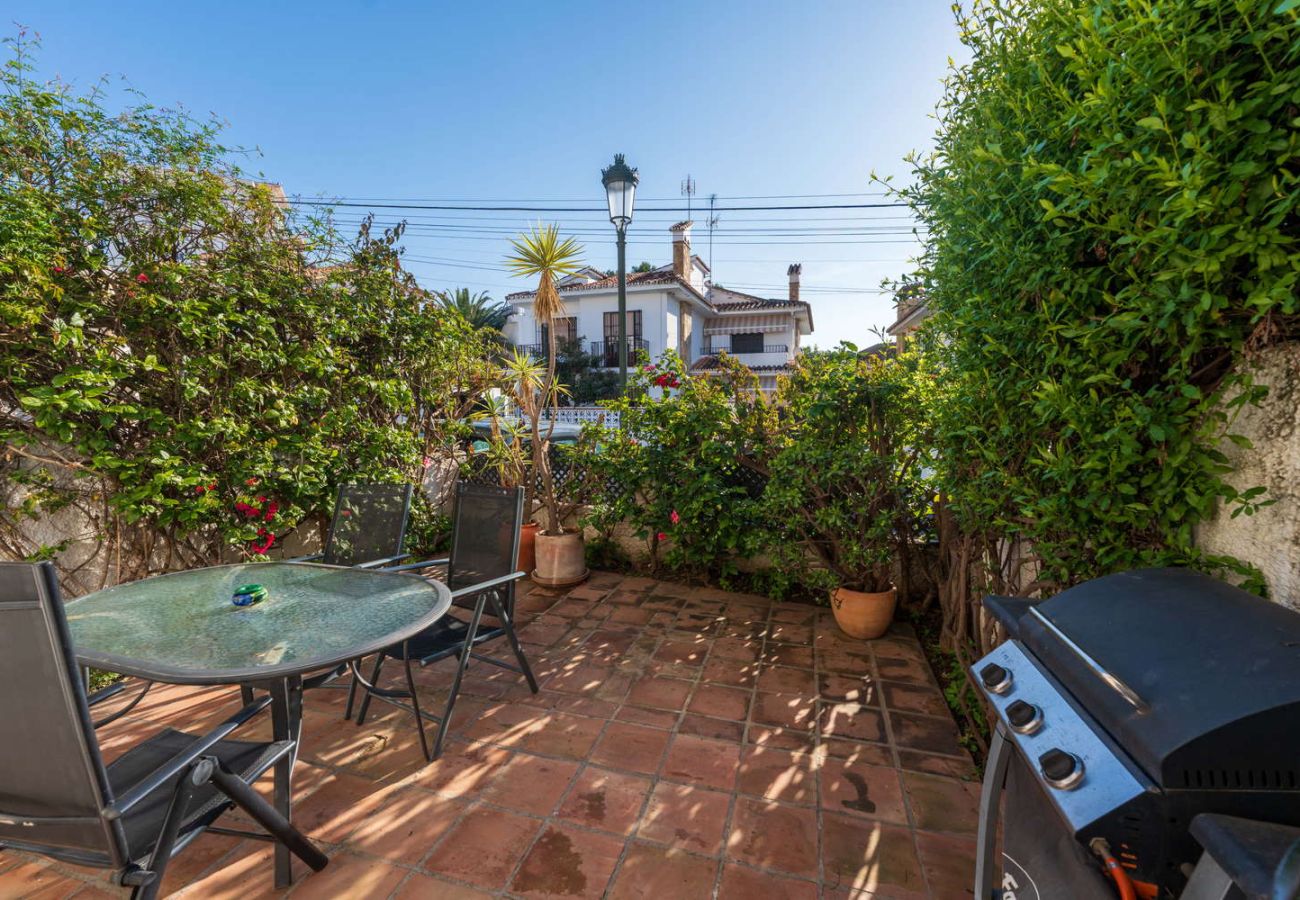 Terraza privada con mesa de comedor exterior y barbacoa de gas en la urbanización Verano Azul.