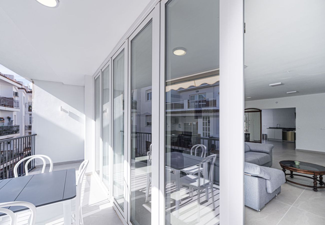 Comedor exterior en la terraza conectado al salón de apartamento vacacional en Nerja.