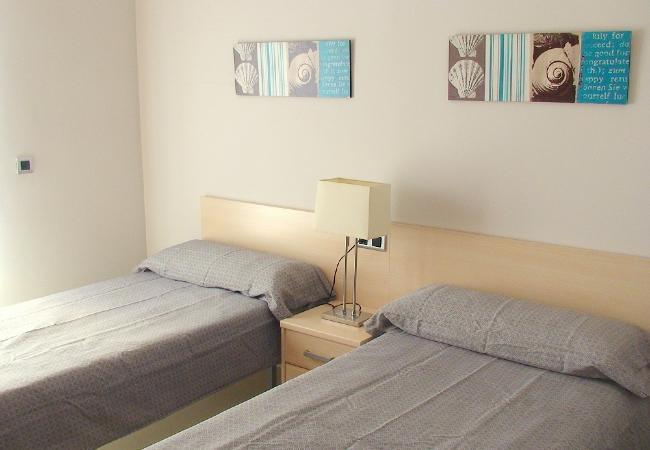 The second bedroom has 2 single beds and a bedside table. The bedsheets are included. 
