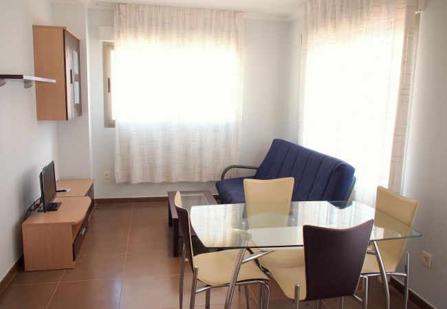 The living-dining area has a sofa, a TV, a dining table with chairs and other furniture. Its light, airy and spacious.