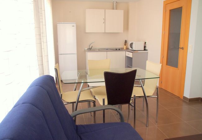 The living-dining area has a sofa, a TV, a dining table with chairs and other furniture. Its light, airy and spacious.
