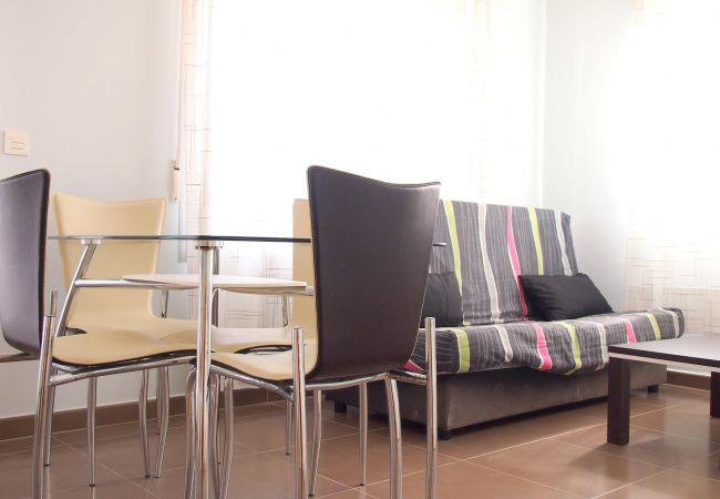 The living-dining area has a sofa, a TV, a dining table with chairs and other furniture. Its light, airy and spacious.