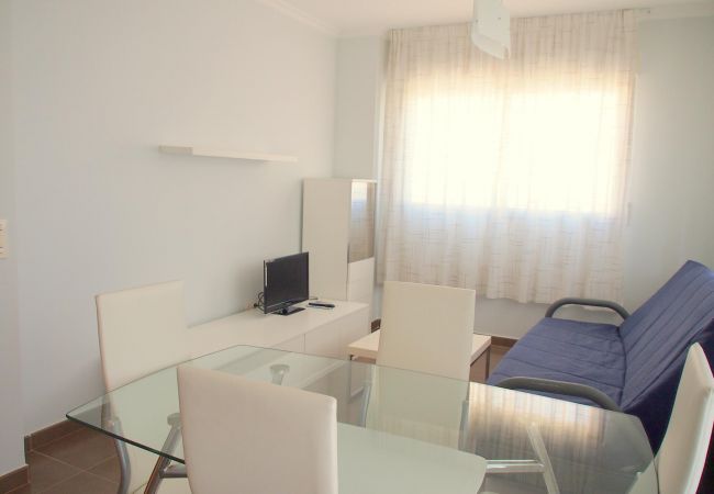 The living-dining area has a sofa, a TV, a dining table with chairs and other furniture. Its light, airy and spacious.