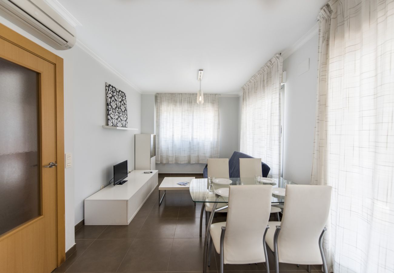 The living-dining space has a dining table and chairs, a sofa, a televisión and more furnishings.