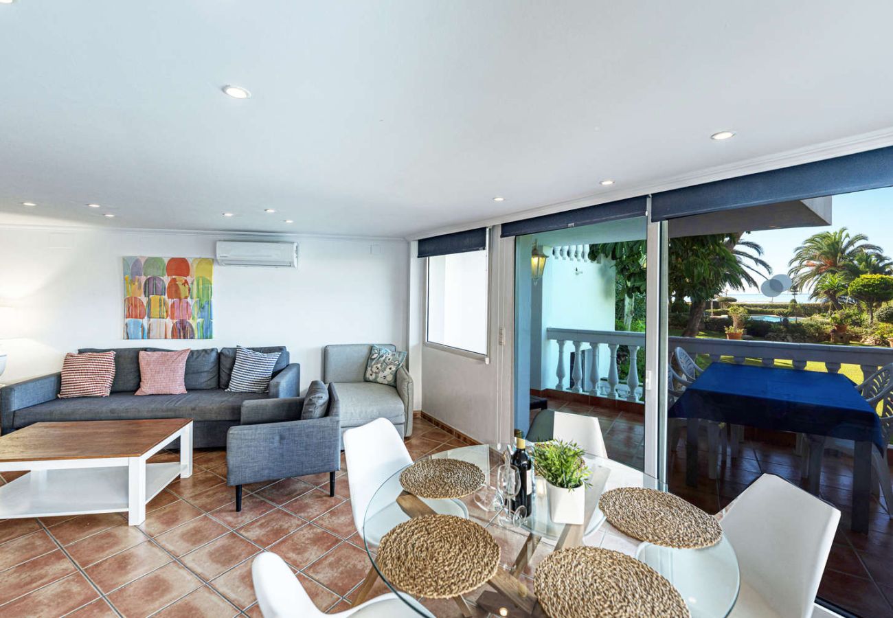 Living room interior with open sea and pool views through the terrace windows