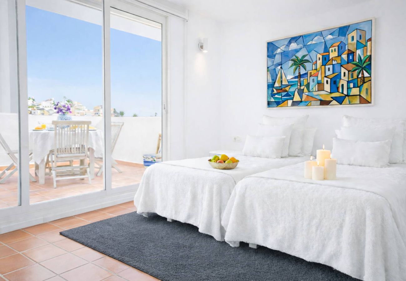 Bedroom connecting to the rooftop terrace with outdoor dining area in Nerja.