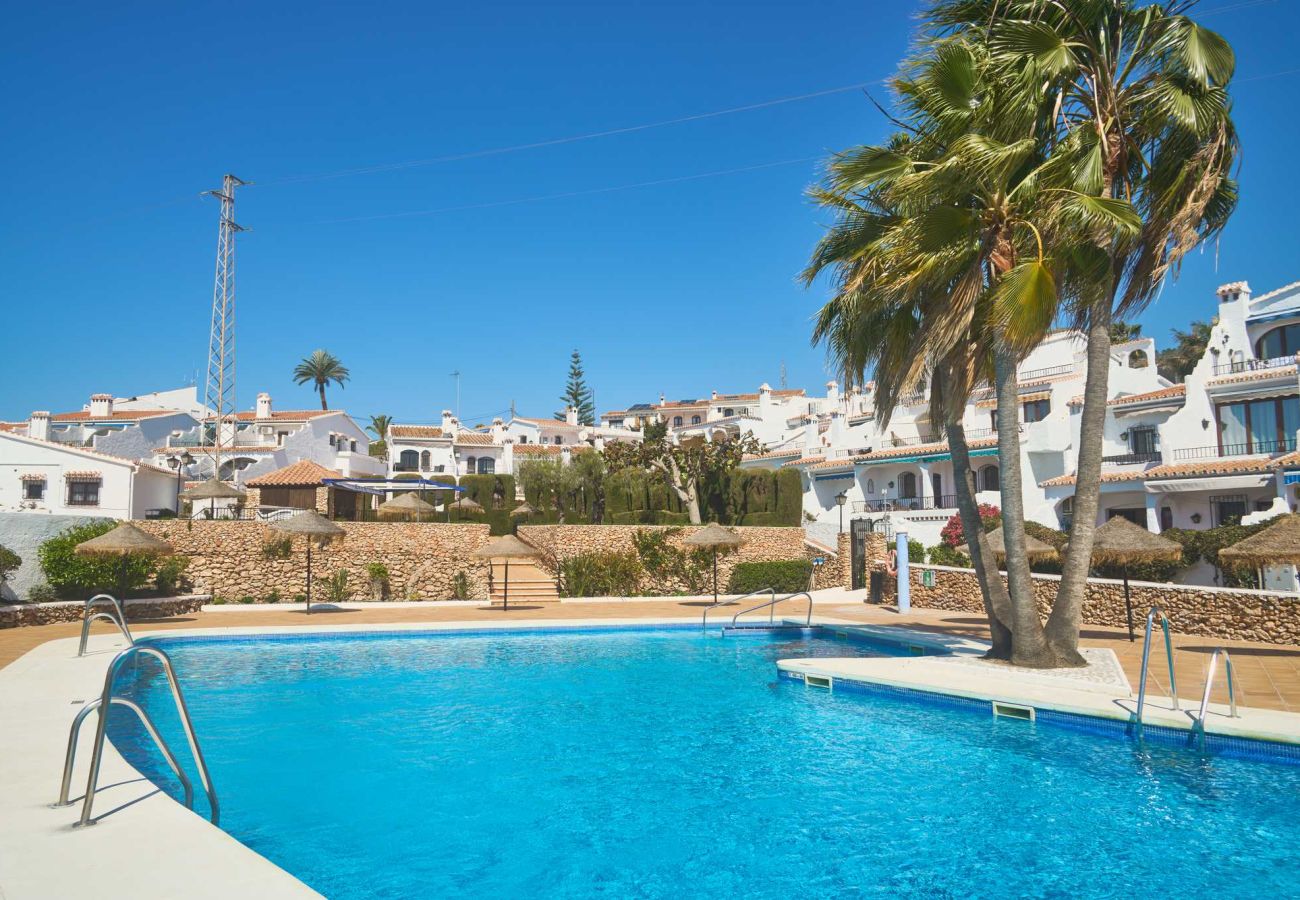 Casa Sofia Communal swimming pool surrounded by gardens at the Capistrano Village complex, Nerja.