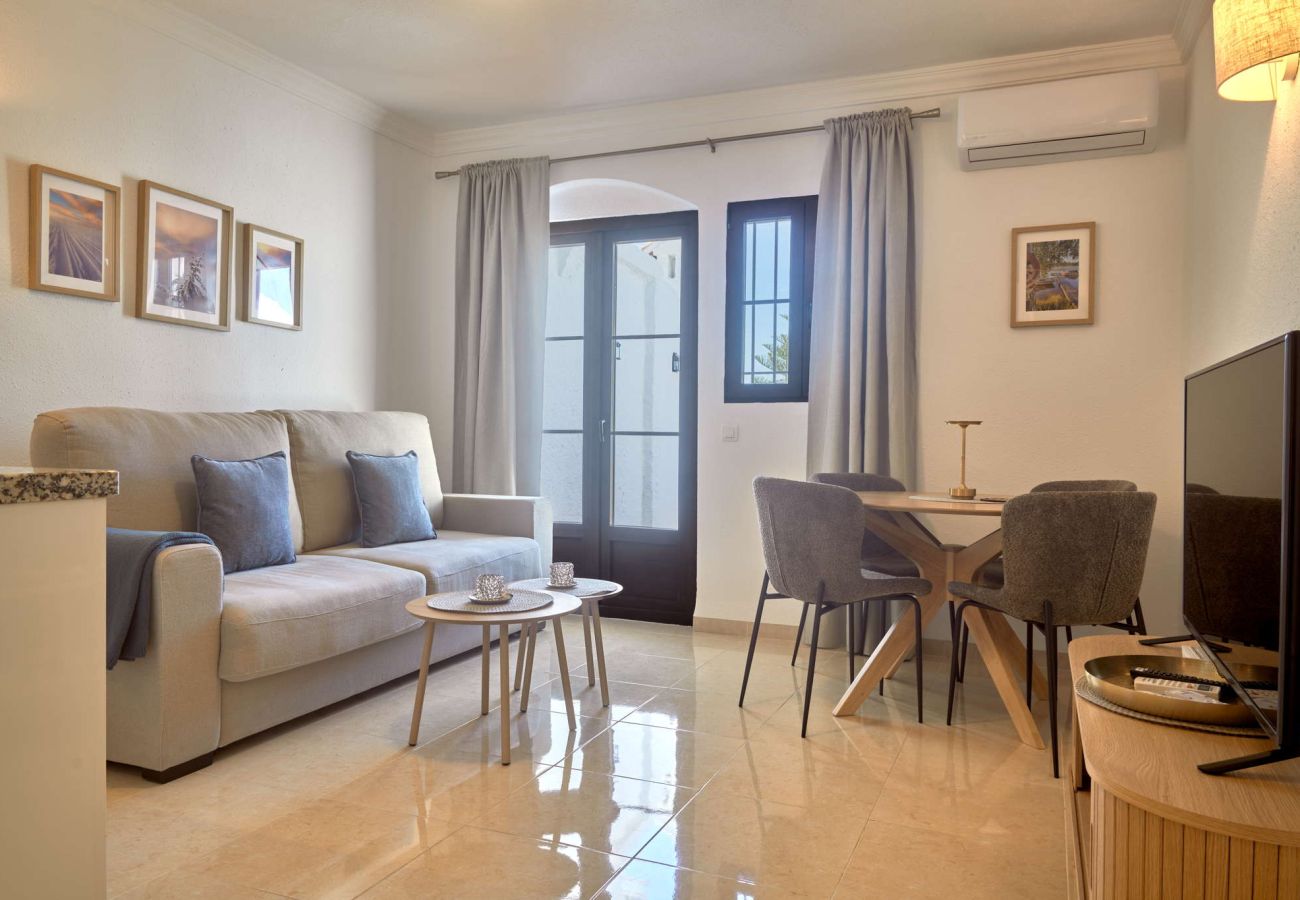 Modern living room with sofa, dining area, and air conditioning at Casa Sofia apartment, Capistrano Village.