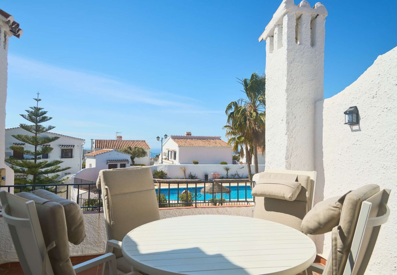 Private terrace in Capistrano Village Nerja with dining table and views of the communal pool.